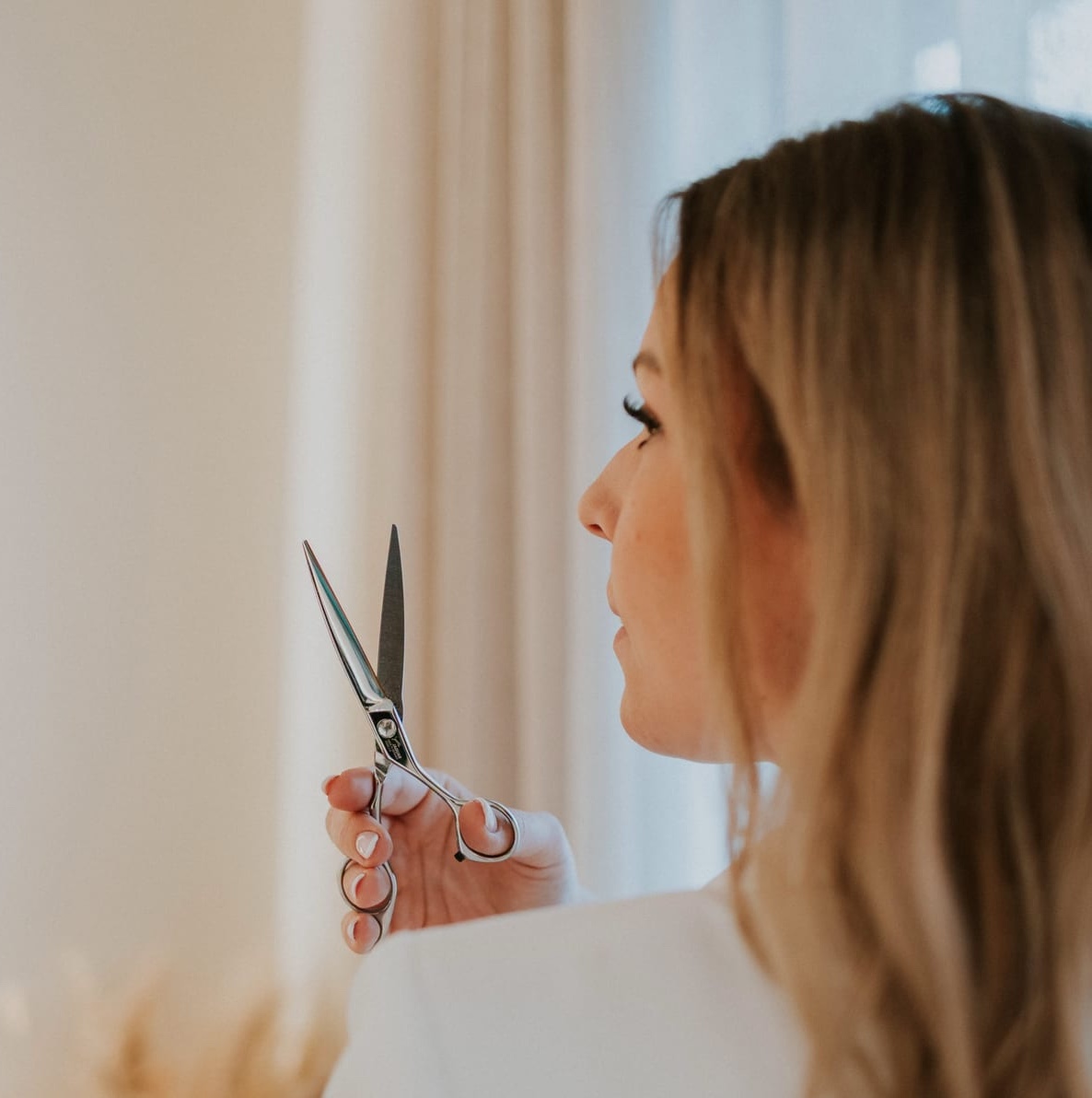 Kapster van Haarsalon Magnifiek knipt haar met een schaar
